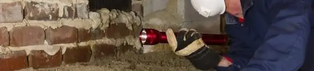 Pest control technician inspecting a crawl space for ant activity and entry points in Boulder, CO
